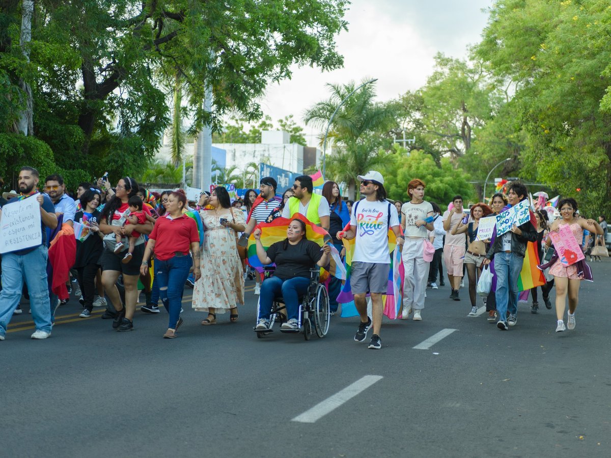 Participantes en una marcha portando banderas como símbolo de inclusión