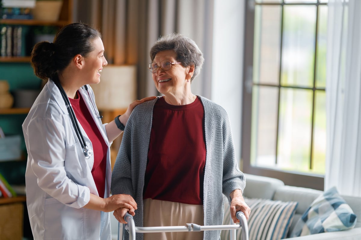 Profesional de la salud conversando de forma cálida con una paciente en su hogar